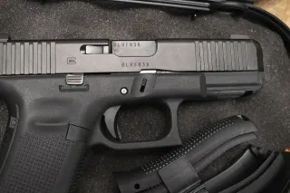 A matte black Glock 45 9mm pistol with a clip.