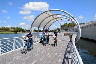 Facing a small group of people riding bicycles on the Riverwalk.